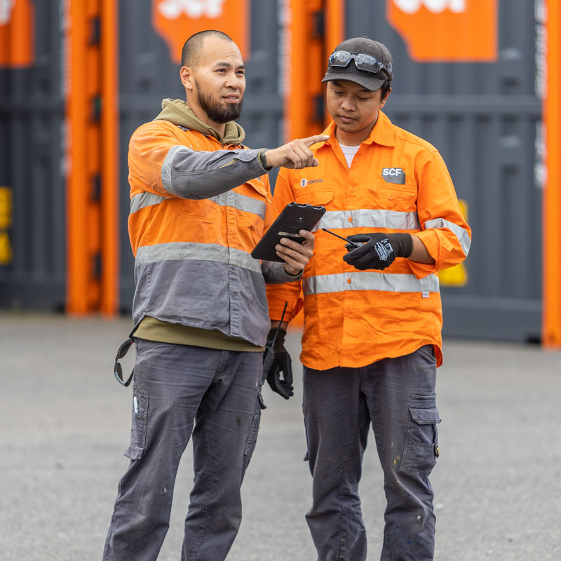Two SCF workers reviewing the proprietary container management system, Gater